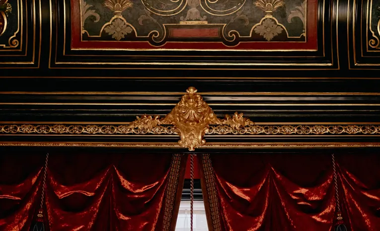 Lined curtains hanging with soft folds by a window